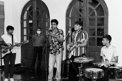 May be a black-and-white image of 5 people, people standing, people playing musical instruments, guitar and indoor